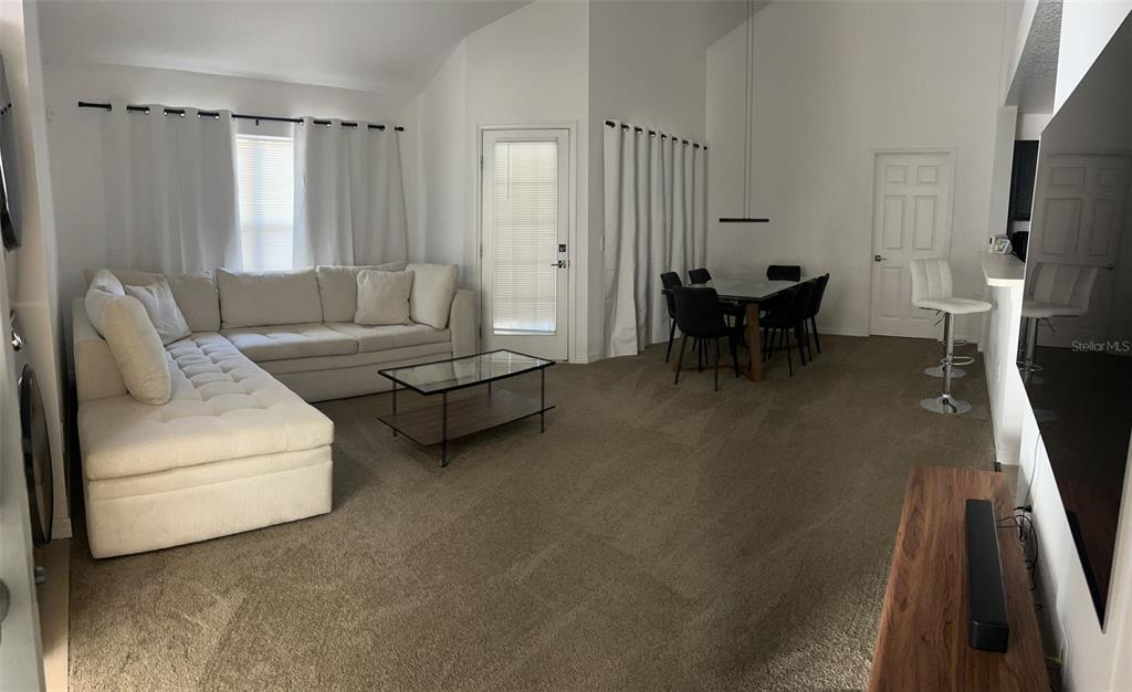 A living room features a white sectional sofa, a glass coffee table, and a dining area — 970 N SPRING GARDEN AVENUE UNIT 621, DELAND, FL