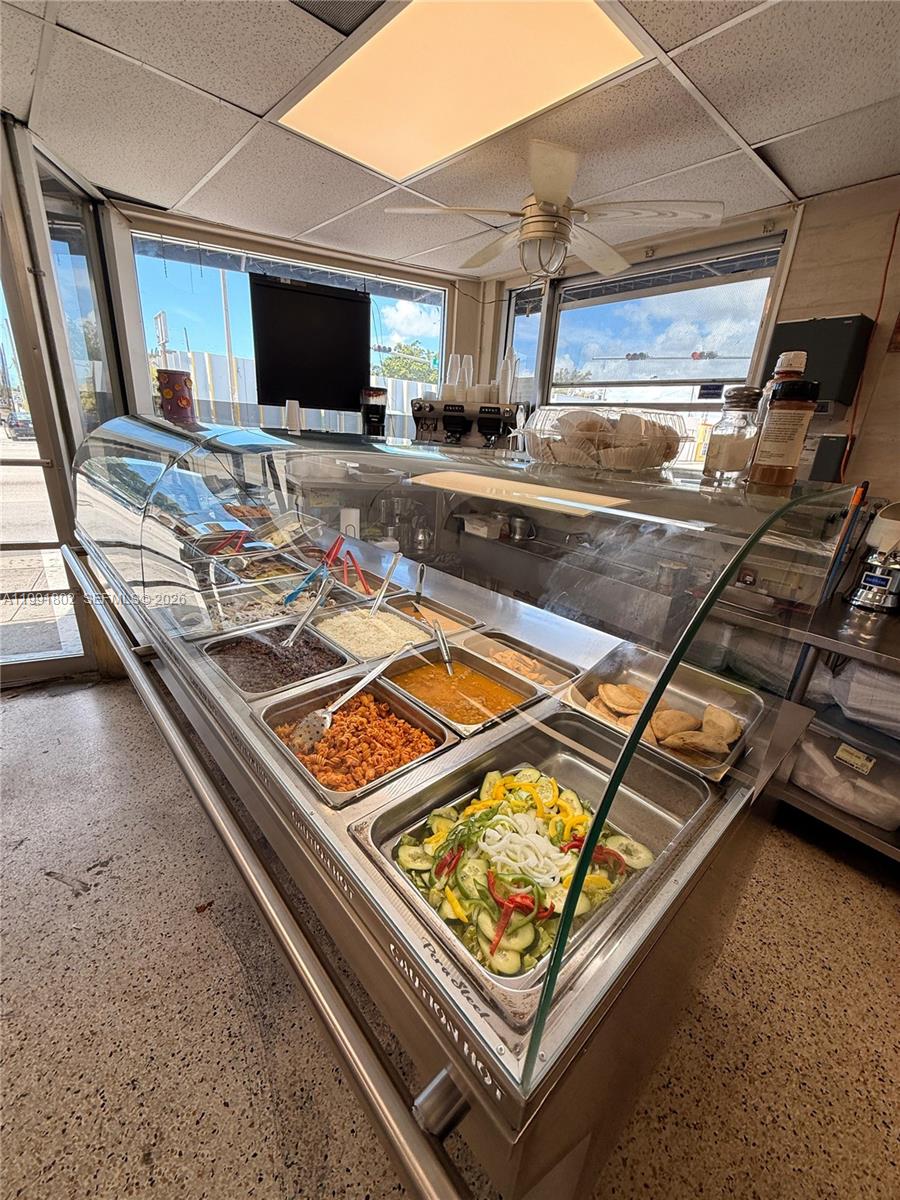 A commercial food service counter features a glass display case filled with prepared hot dishes — 3381 NW 7th St, Miami FL 33125, MIAMI, FL