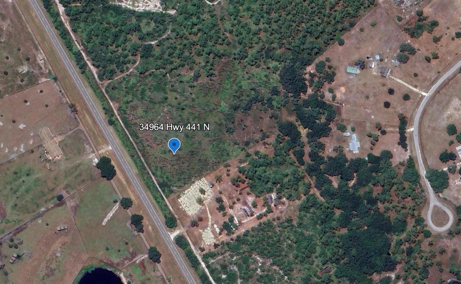 This satellite map shows a wooded plot of land located next to a highway — 34964 N Hwy 441, Okeechobee FL 34972, OKEECHOBEE, FL
