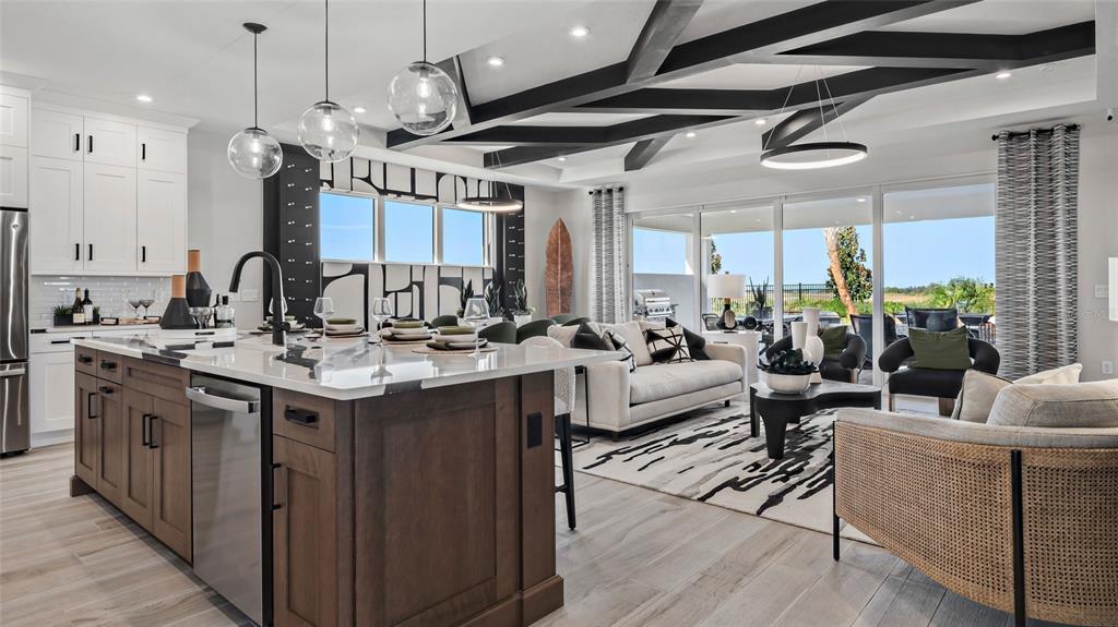 A modern open-concept kitchen and living area featuring dark wood cabinetry, ceiling beams, and furniture — 1736 POINT GRACE ROAD, TAVARES, FL