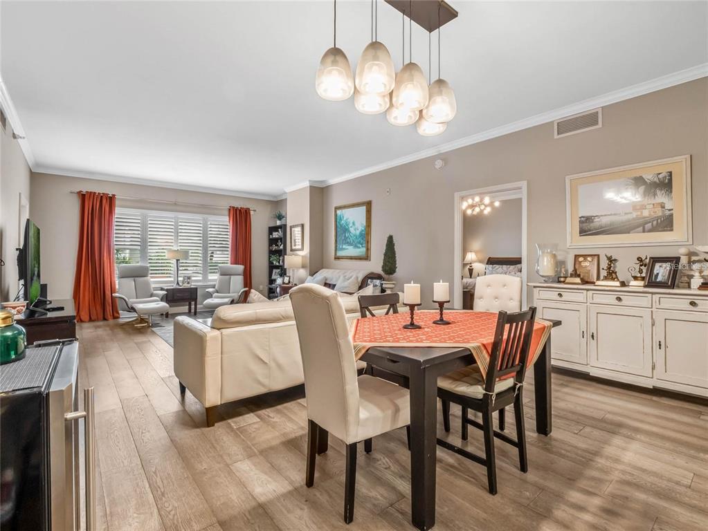 A dining area with a dark table and chairs sits in front of a living room — 630 VASSAR STREET UNIT 2205, ORLANDO, FL