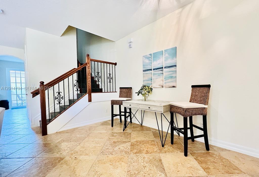 A tiled entryway features a staircase with a wooden railing and a small desk area — 753 DAKOTA DR # 753, Jupiter FL 33458, JUPITER, FL