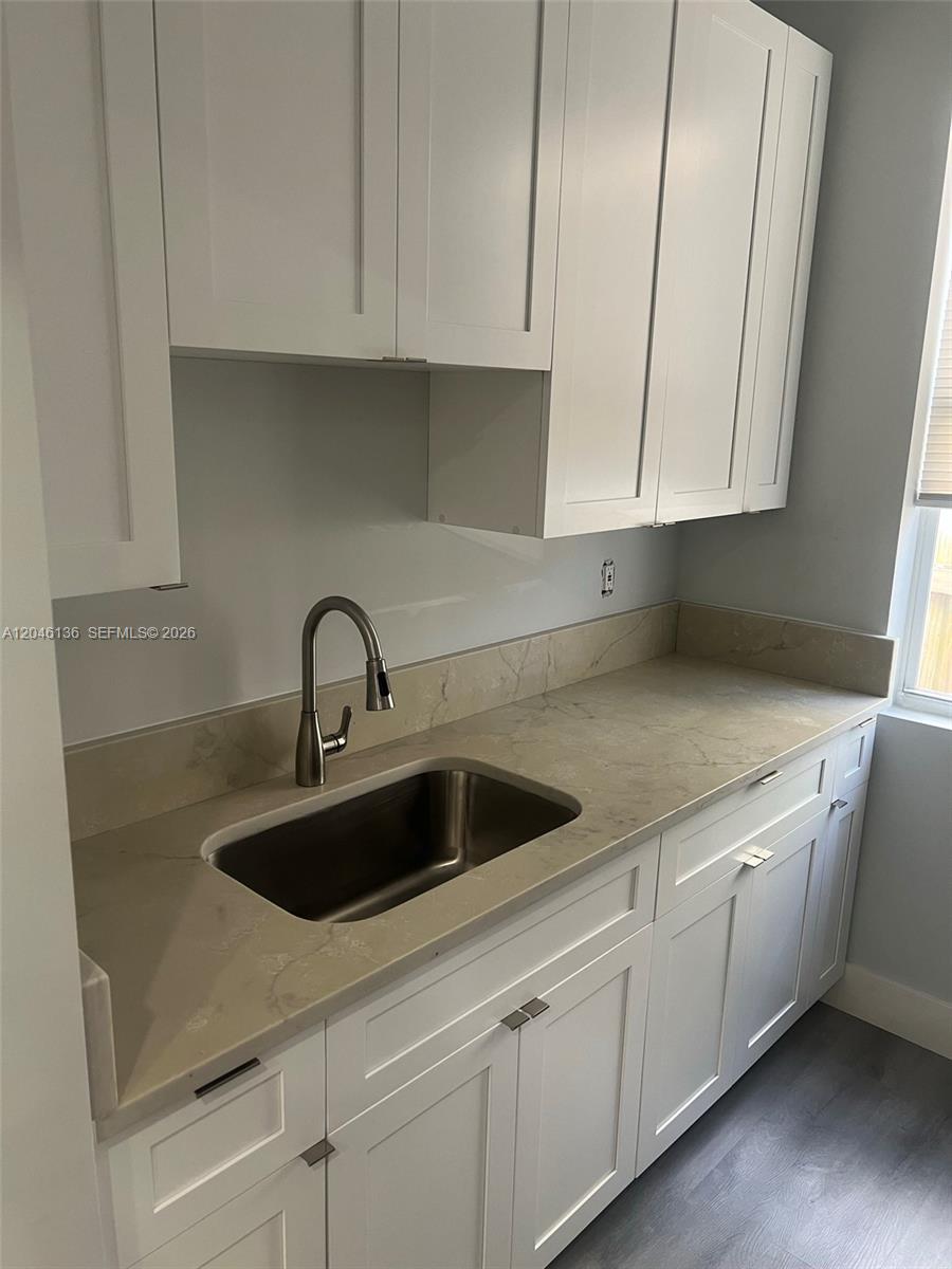 A kitchen features white shaker cabinets, a stainless steel sink, and light-colored stone countertops — 1450 SW 4th St # 3, Miami FL 33135, MIAMI, FL