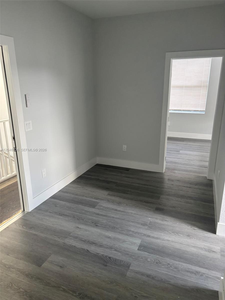 An empty room with gray walls and wood-look flooring features two doorways — 1450 SW 4th St # 3, Miami FL 33135, MIAMI, FL