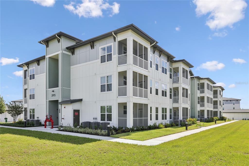 A three-story apartment building with screened balconies and a red fire hydrant in front — 4005 BISMARK DRIVE UNIT C1, KISSIMMEE, FL