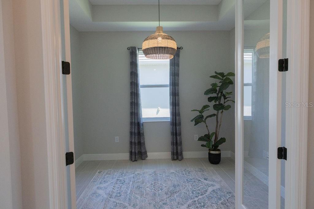 A small room with a tray ceiling, a woven pendant light, and a potted plant — 8100 SLIPWAY DRIVE, SARASOTA, FL