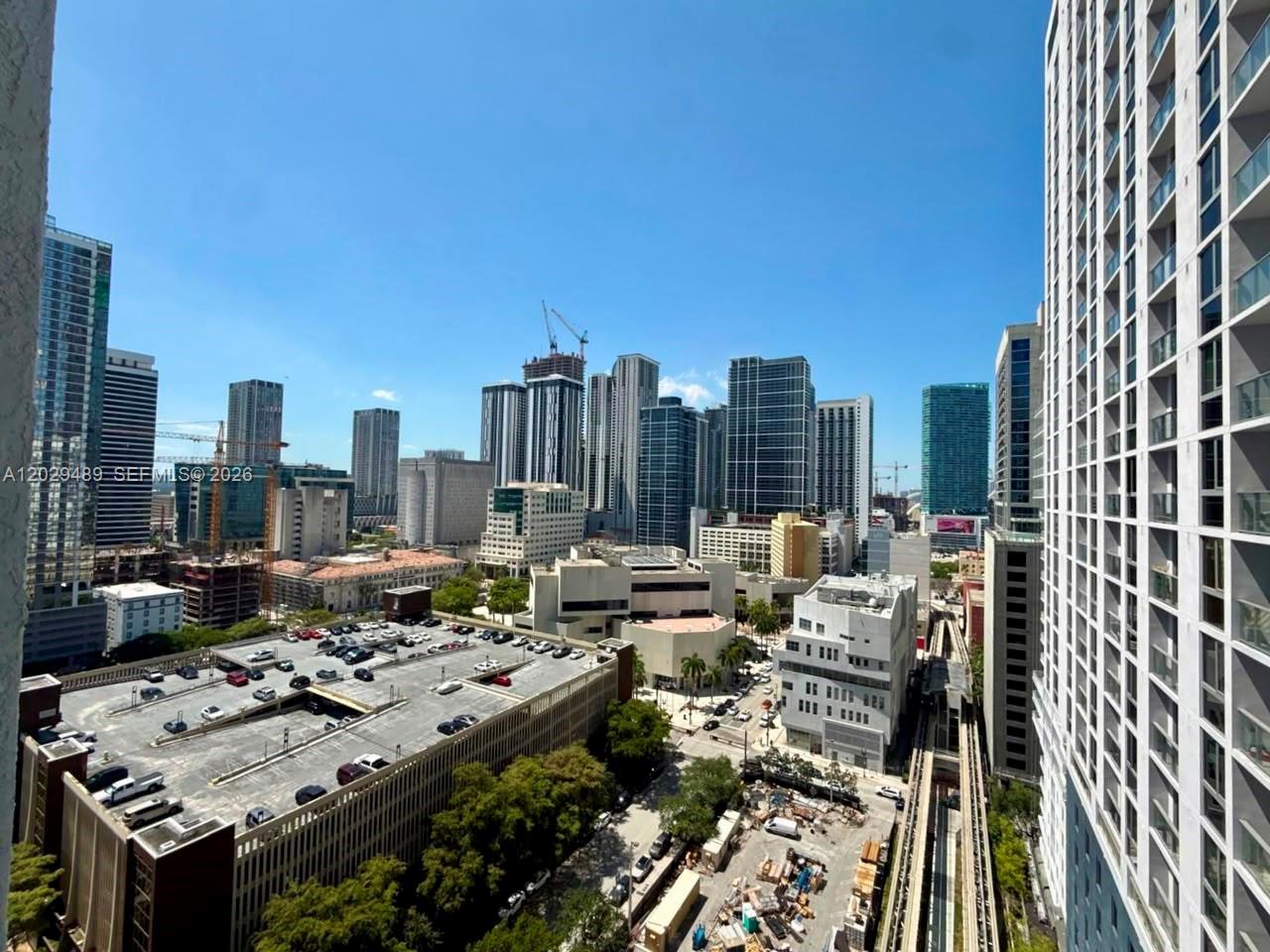 An elevated view of a city skyline featuring high-rise buildings and a parking garage — 133 NE 2nd Ave # 1905, Miami FL 33132, MIAMI, FL