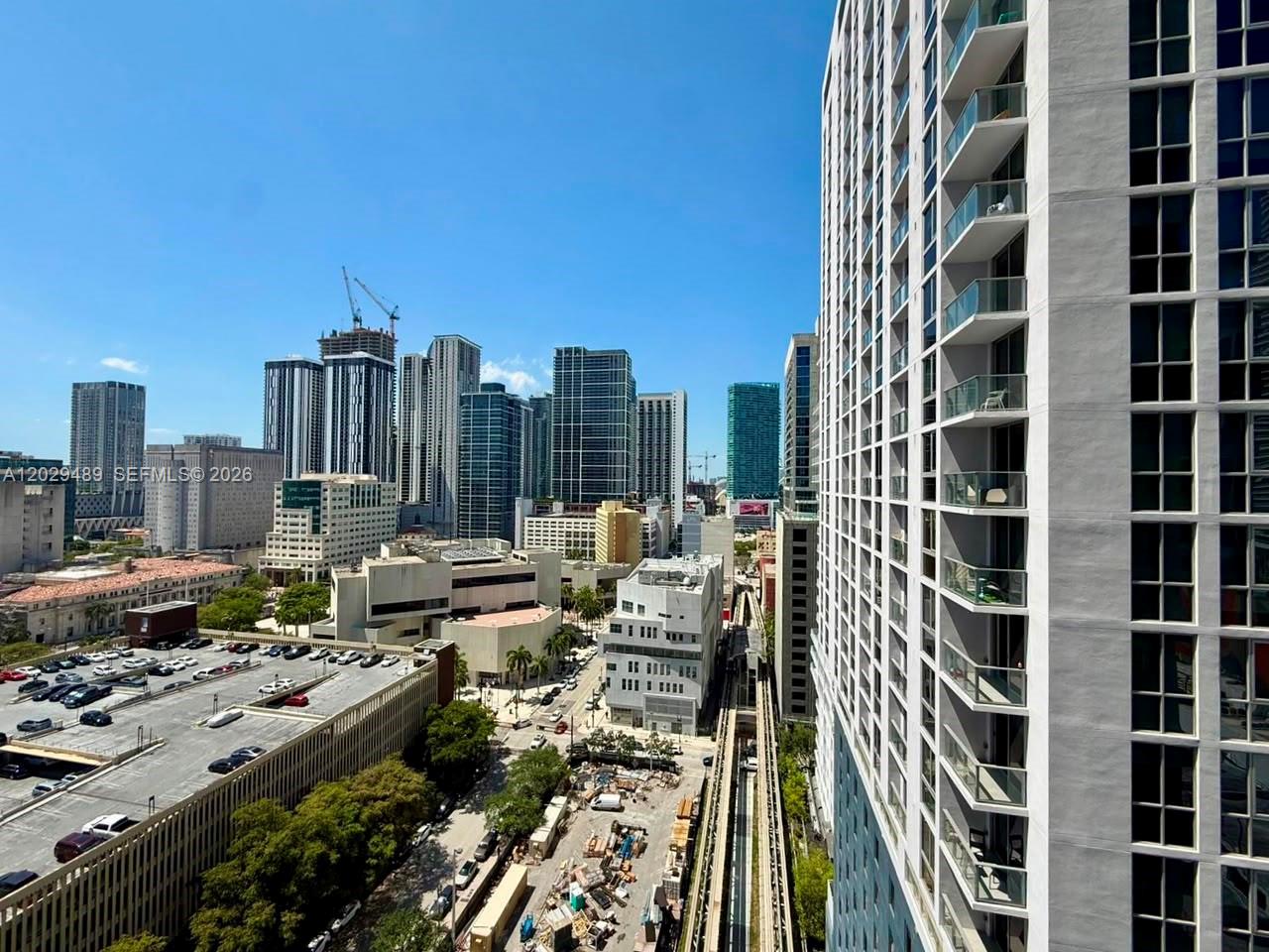 An elevated view of a city skyline featuring high-rise buildings, a parking garage, and tracks — 133 NE 2nd Ave # 1905, Miami FL 33132, MIAMI, FL