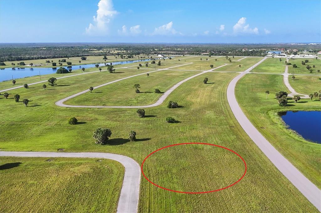 An aerial view of a vacant, grassy residential lot outlined in red within a subdivision — 23 REDWOOD DRIVE, PLACIDA, FL
