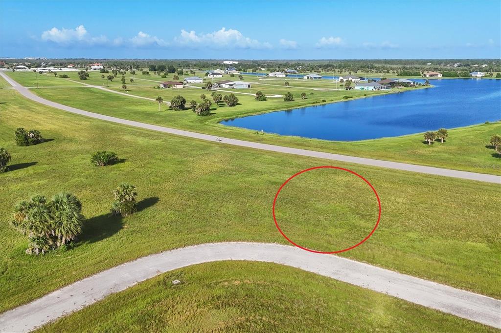 An aerial view shows a vacant, grassy residential lot marked by a red circle — 23 REDWOOD DRIVE, PLACIDA, FL