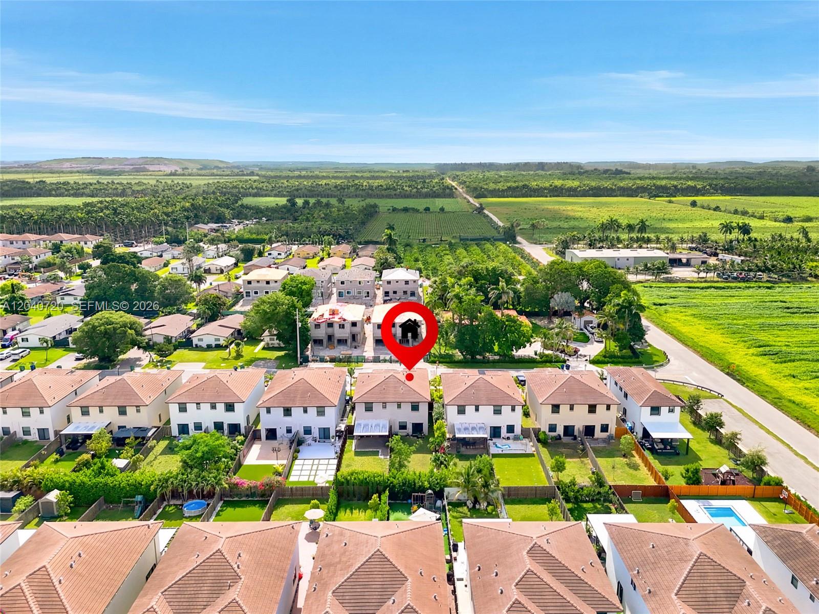 An aerial view shows a residential neighborhood with a red location pin marking a house — HOMESTEAD, FL