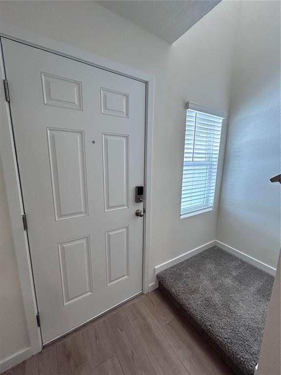 A two-story townhouse exterior features a concrete driveway, a white garage door, and dark doors — 760 PRESTON COVE DRIVE, ST CLOUD, FL