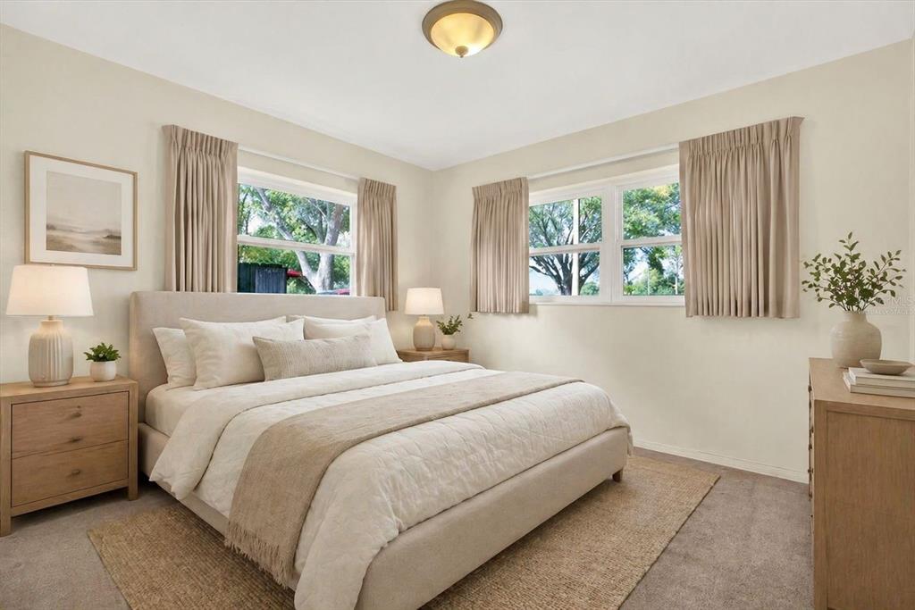 A bedroom features a neutral color palette, a bed with beige bedding, and two windows — 2561 58TH STREET N, ST PETERSBURG, FL