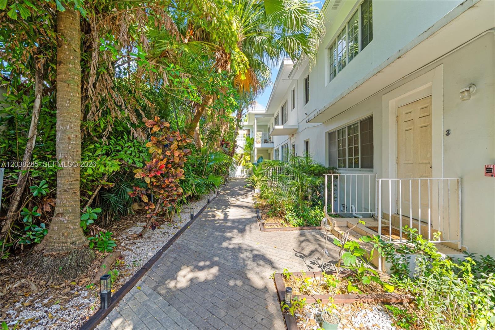 A paved walkway leads past a white building with a numbered door and lush landscaping — 840 Lenox Ave # 3, Miami Beach FL 33139, MIAMI BEACH, FL