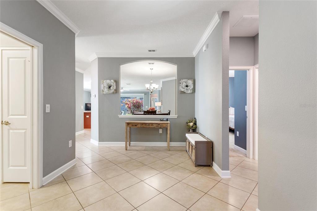 A tiled entryway features a console table beneath an arched wall cutout looking into a room — 1414 CLUBMAN DR, DAVENPORT, FL