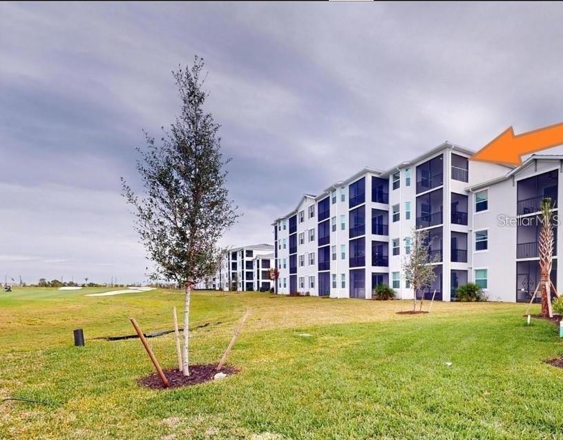Exterior view of a multi-story apartment building with screened balconies overlooking a golf course — 17565 OPAL SAND DRIVE UNIT 401, VENICE, FL
