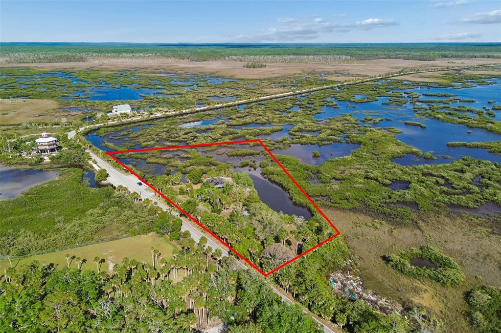 An aerial view shows a property outlined in red surrounded by marshland and water — 10501 PINE ISLAND DRIVE, WEEKI WACHEE, FL