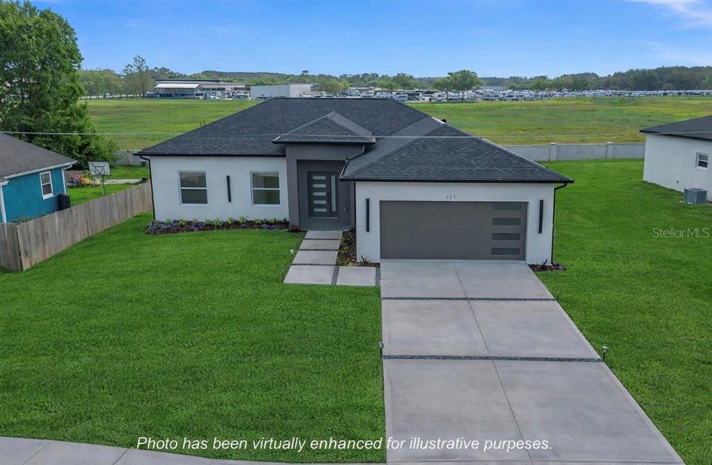An aerial view shows a modern single-story house with a gray garage and driveway — 1231 DUNBAR AVENUE, SANFORD, FL