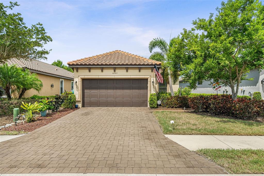 A single-story house with a brown garage door, tiled roof, and a paved driveway — 10205 SAINT FRANCIS TERRACE, PALMETTO, FL