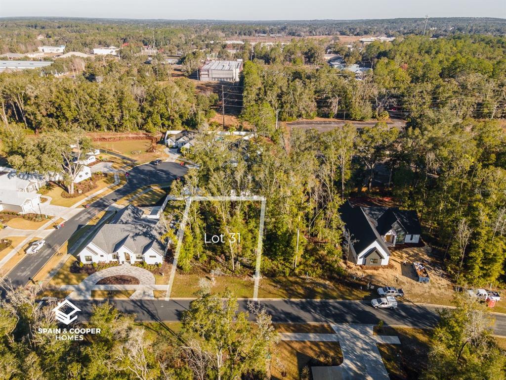 An aerial view shows a vacant, wooded residential lot labeled Lot 31 between two houses — 14146 SW 7TH PLACE, NEWBERRY, FL