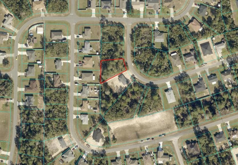 An aerial view shows a vacant, wooded residential lot outlined in red within a neighborhood — SW 128TH STREET ROAD, OCALA, FL