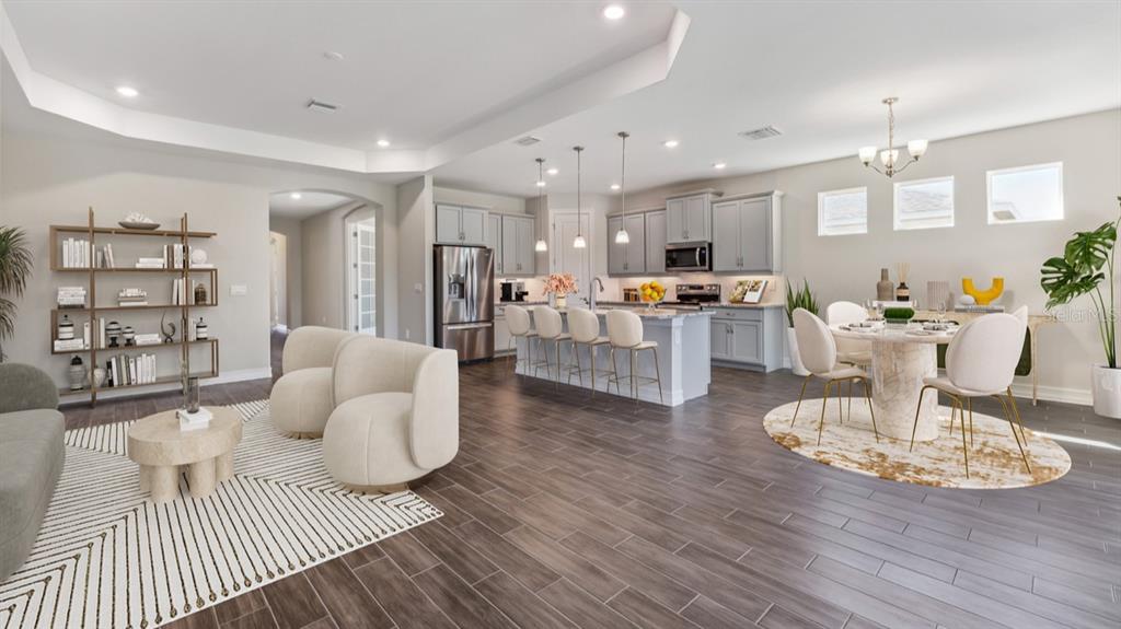 An open-concept kitchen and living area features gray cabinetry, a kitchen island, and tile flooring — 12736 SEAGRASS DRIVE, PUNTA GORDA, FL