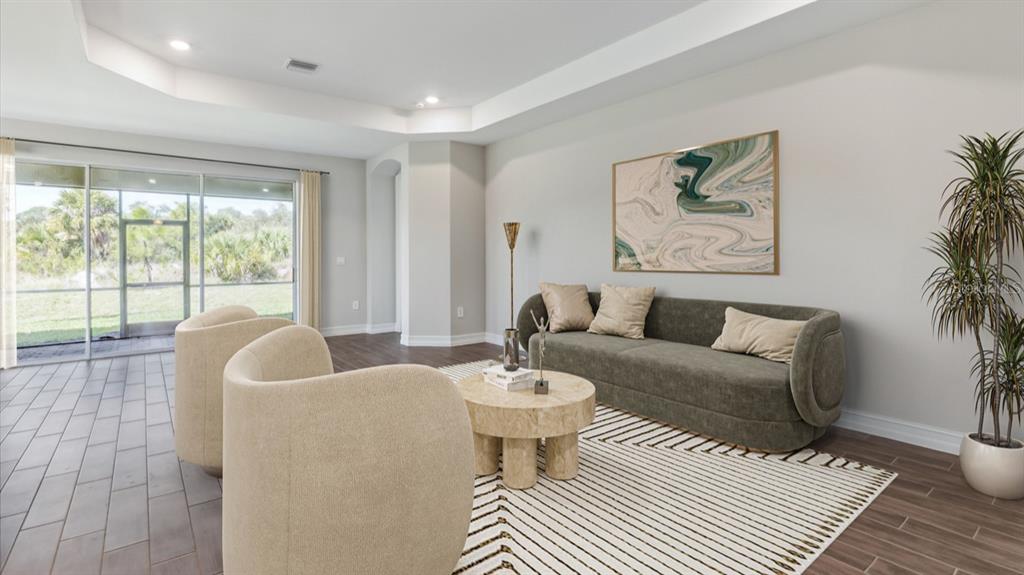 A living room features a green sofa, two beige armchairs, a coffee table, and sliding doors — 12736 SEAGRASS DRIVE, PUNTA GORDA, FL