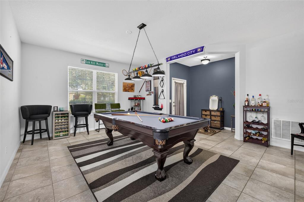 A game room features a pool table, a striped rug, and a bar area — 12637 OLD PLANTATION LANE, ORLANDO, FL