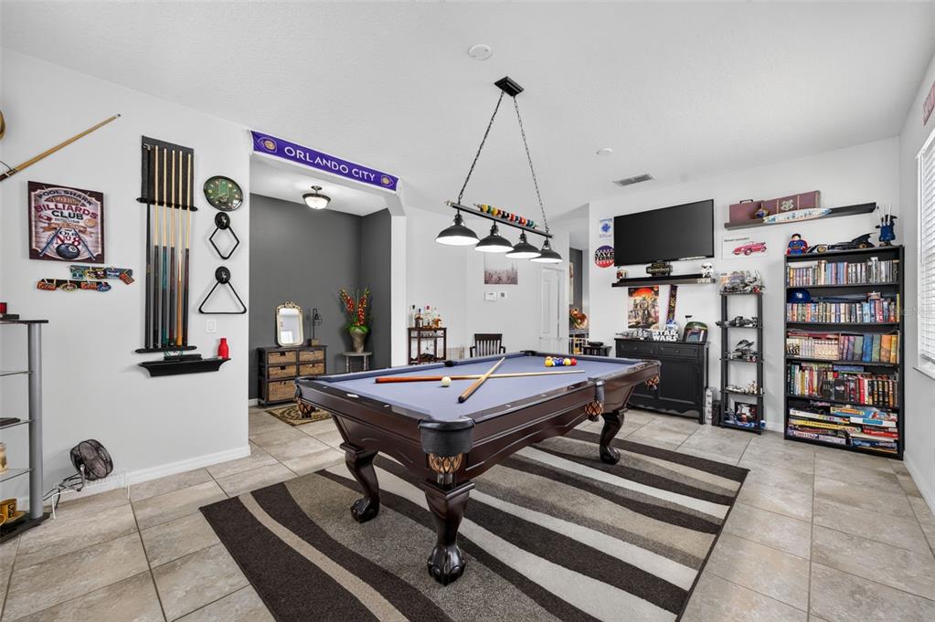 A game room features a pool table, a wall-mounted cue rack, and a bookshelf — 12637 OLD PLANTATION LANE, ORLANDO, FL