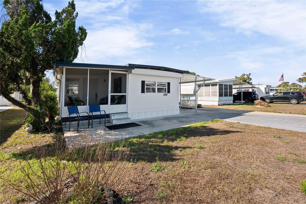 A white mobile home with a screened-in porch and a concrete driveway — 37332 SANDRA AVENUE, ZEPHYRHILLS, FL