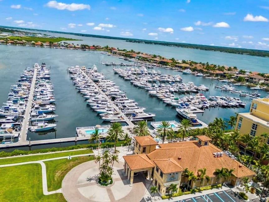 An aerial view shows a large marina filled with boats next to a residential complex — 102 RIVIERA DUNES WAY UNIT N-30, PALMETTO, FL