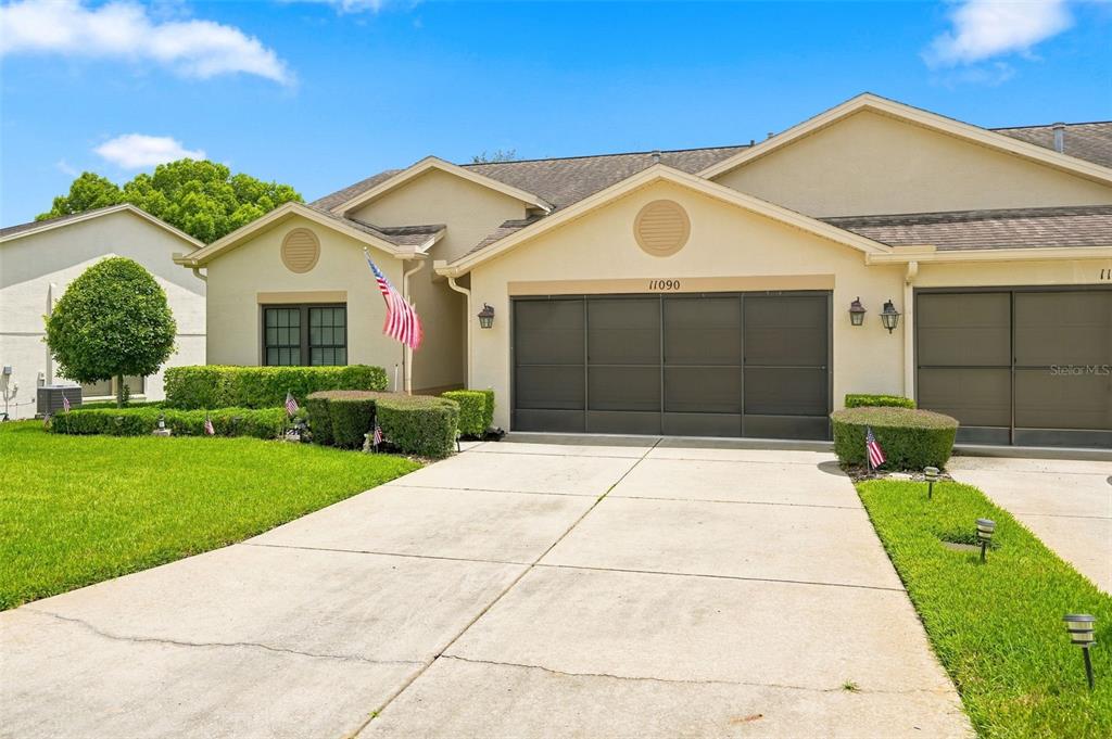 A beige single-story house with a two-car garage and a concrete driveway — 11090 CHERRYWOOD COURT, SPRING HILL, FL