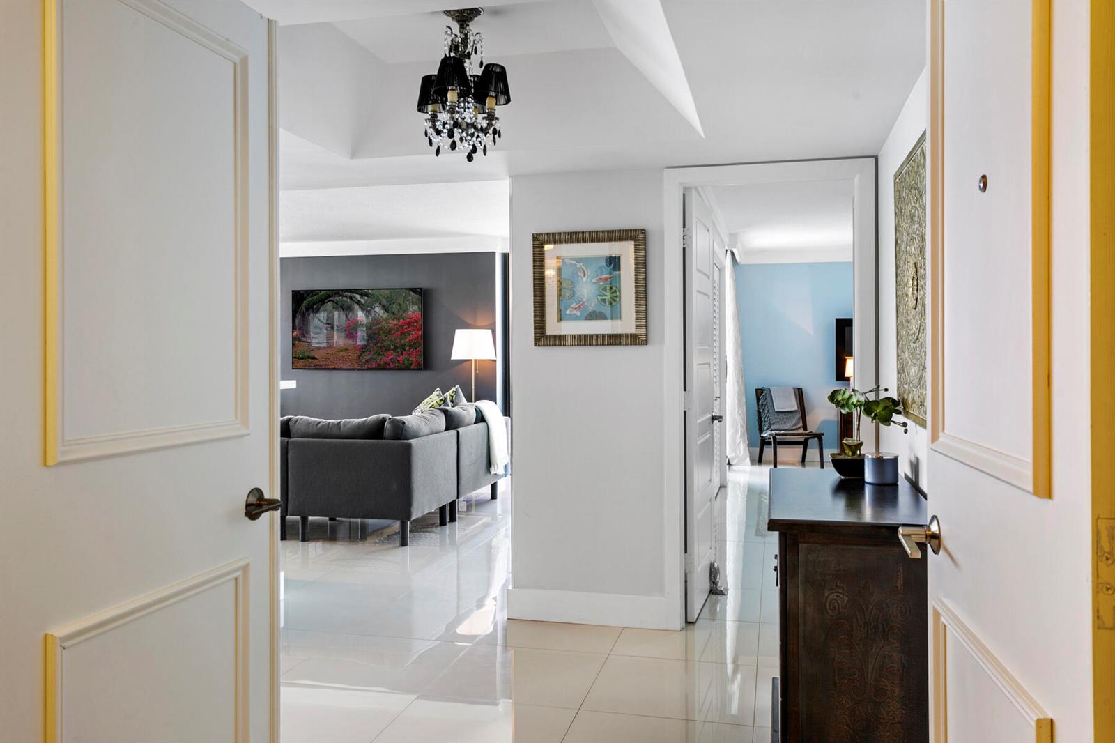 A view from a doorway into a hallway with tile floors, a chandelier, and rooms — 5510 N Ocean Drive # 12a, Singer Island FL 33404, SINGER ISLAND, FL