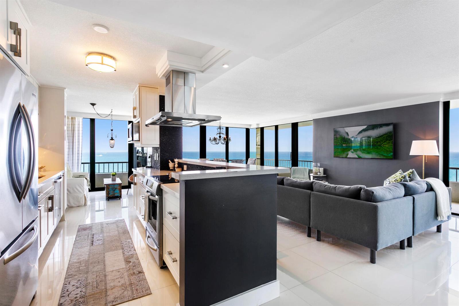 An open-concept kitchen and living area features a dark accent wall and ocean views — 5510 N Ocean Drive # 12a, Singer Island FL 33404, SINGER ISLAND, FL