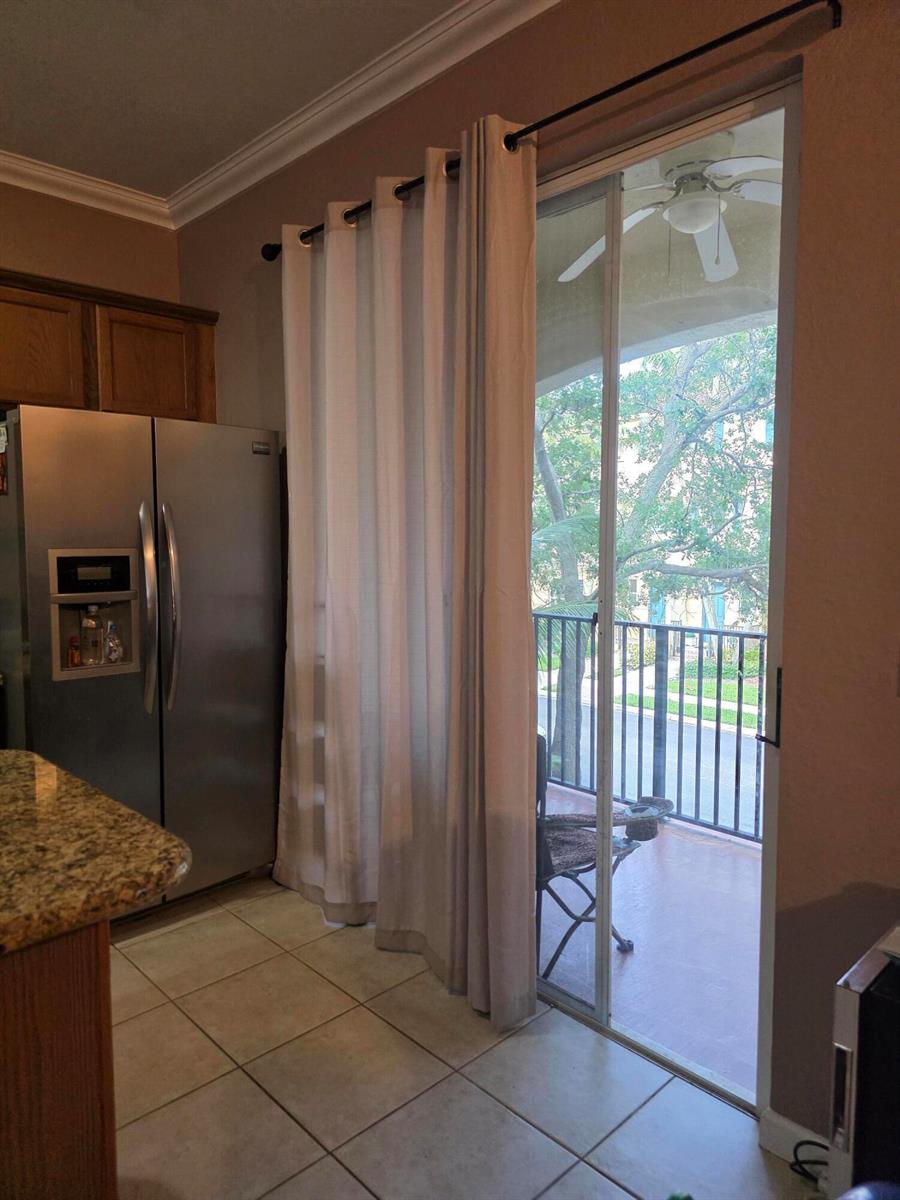 A kitchen with stainless steel appliances and a sliding glass door leading to a balcony — 2866 S Oasis Drive, Boynton Beach FL 33426, BOYNTON BEACH, FL