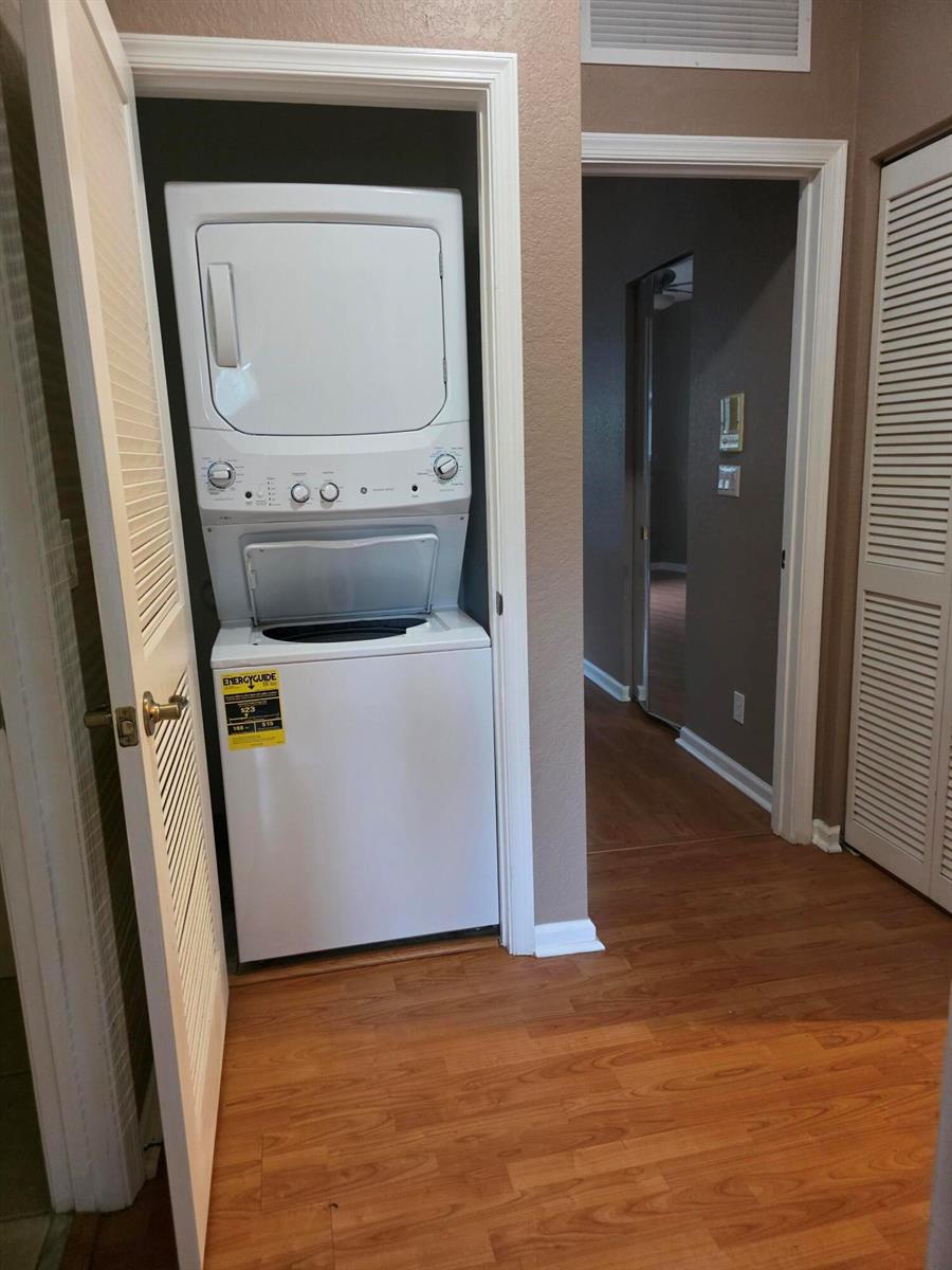 A stacked washer and dryer unit is located in a closet off a hallway — 2866 S Oasis Drive, Boynton Beach FL 33426, BOYNTON BEACH, FL