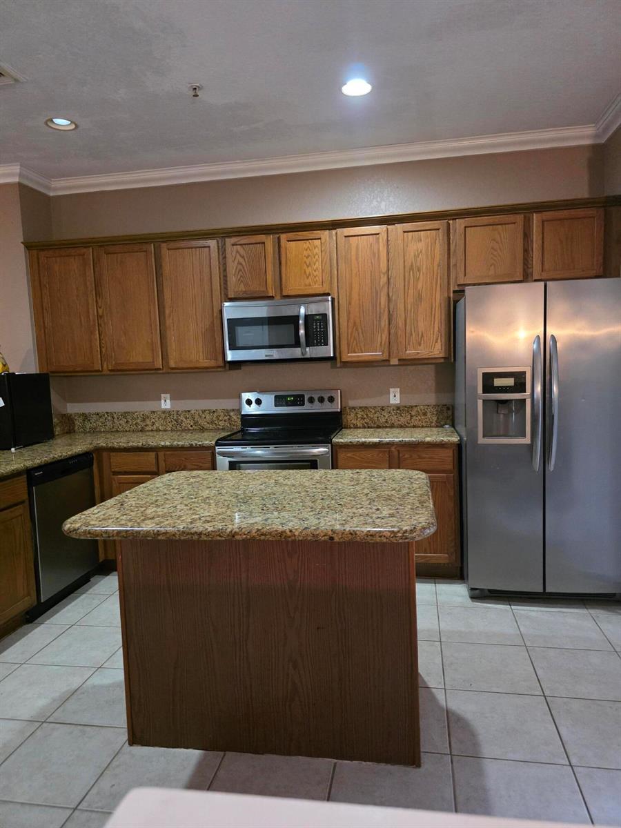 A kitchen features oak cabinets, granite countertops, stainless steel appliances, and a central island — 2866 S Oasis Drive, Boynton Beach FL 33426, BOYNTON BEACH, FL