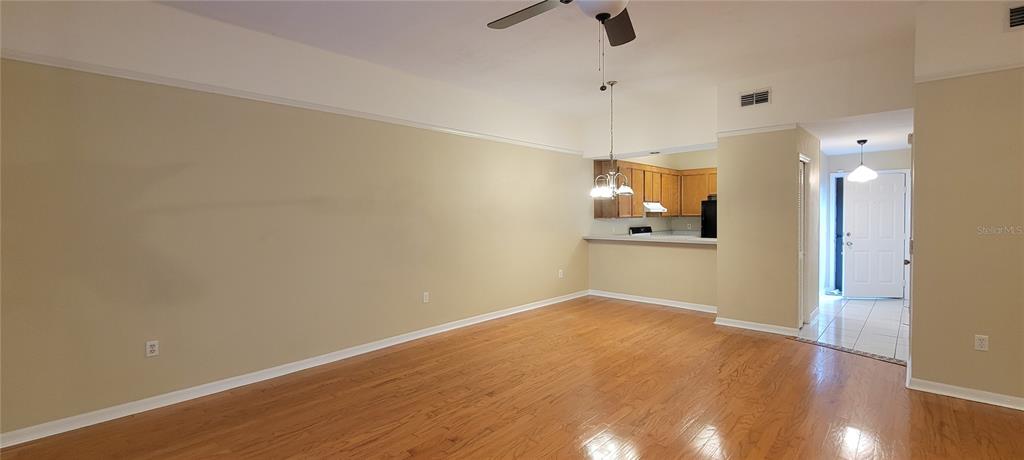 An open living area features hardwood floors, a ceiling fan, and a kitchen breakfast bar — 3760 NW 53RD ROAD, GAINESVILLE, FL
