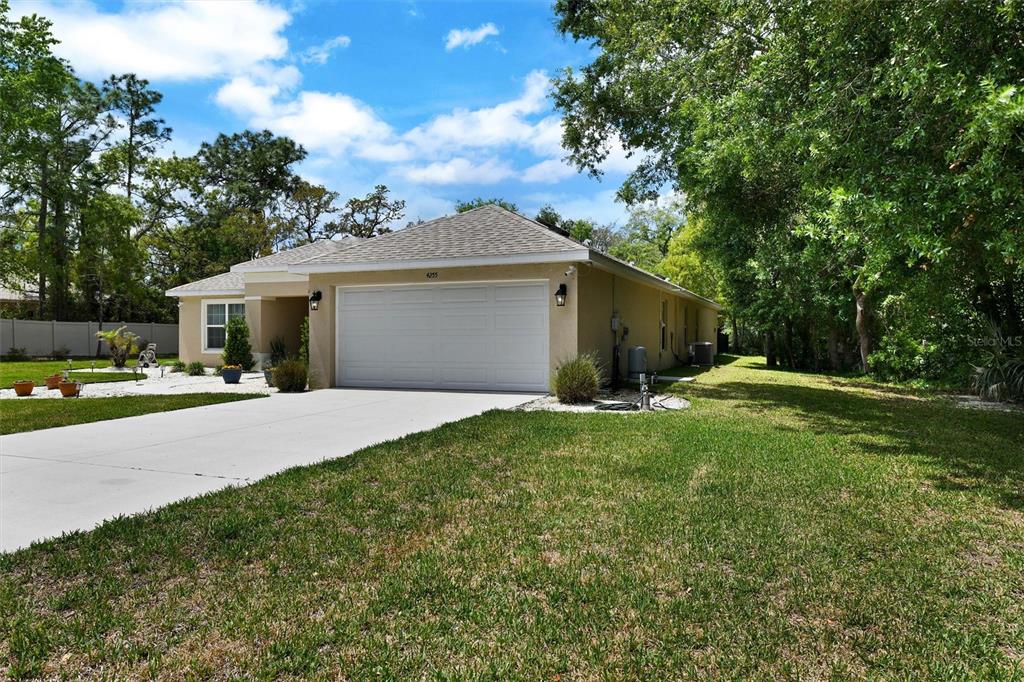 A single-story house with a two-car garage, a concrete driveway, and a grassy front yard — 4255 RACHEL BOULEVARD, SPRING HILL, FL