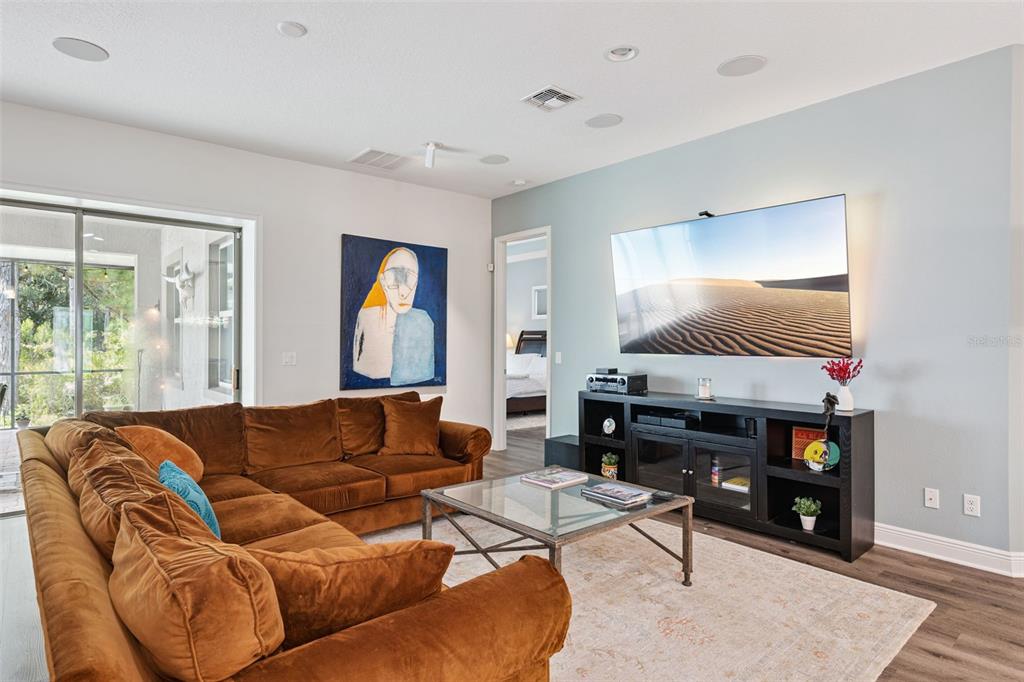 A living room features a brown sectional sofa, a glass coffee table, and a wall-mounted television — 14156 ALAFAYA OAK BEND, ORLANDO, FL