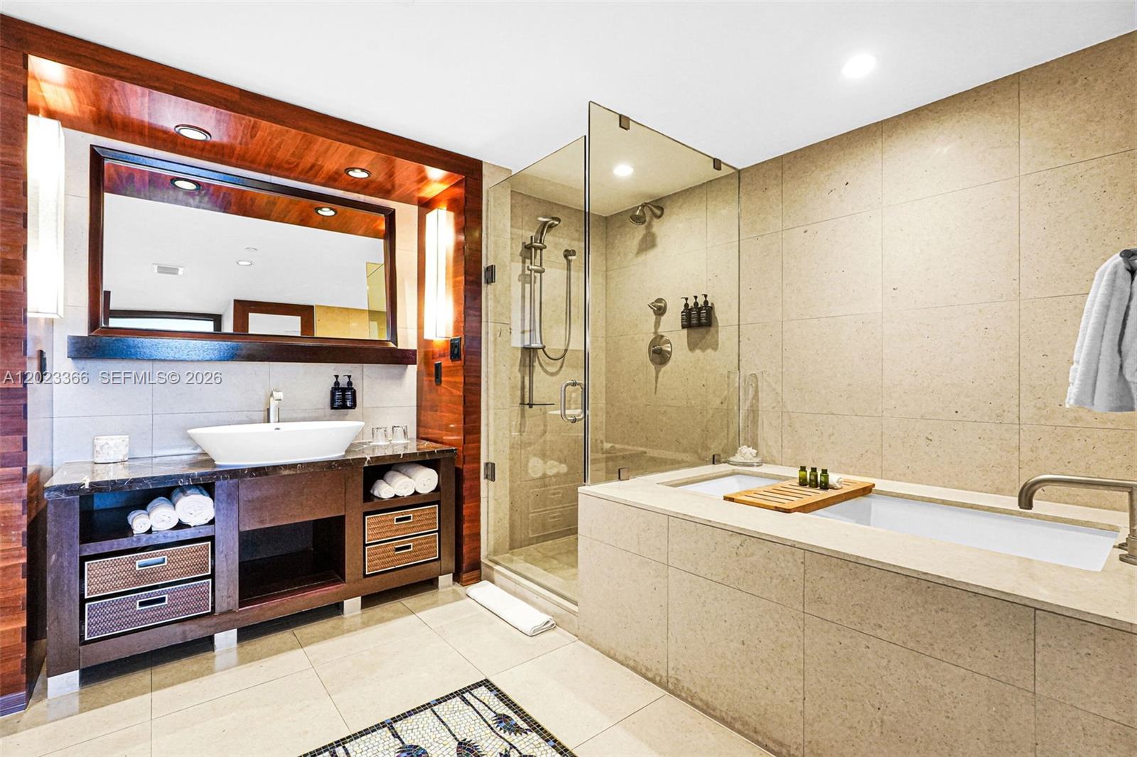 A modern bathroom features a dark wood vanity, a glass-enclosed shower, and a soaking tub — 6801 Collins Ave, Miami Beach FL 33141, MIAMI BEACH, FL