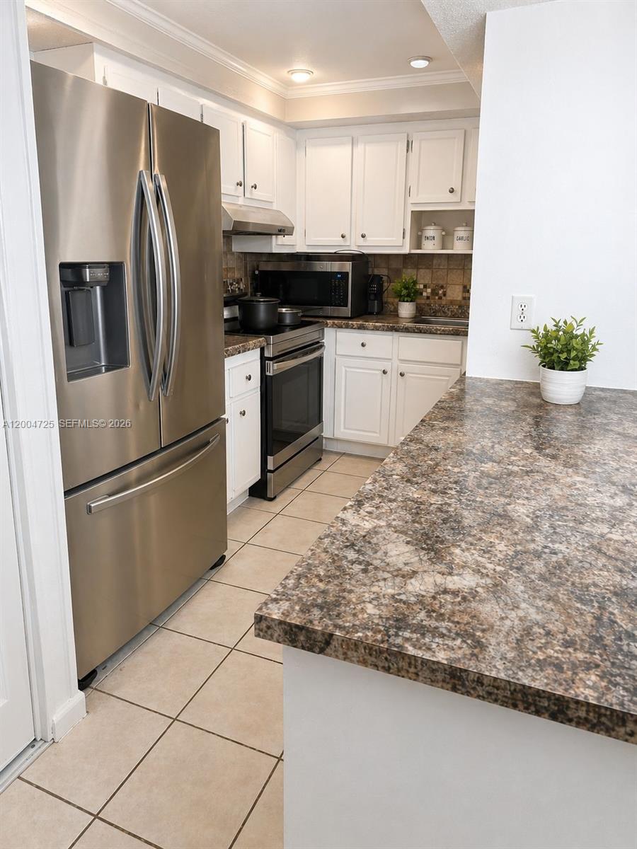 A kitchen features white cabinets, stainless steel appliances, and a brown speckled laminate countertop — 1531 NW 80th Ave # I, Margate FL 33063, MARGATE, FL