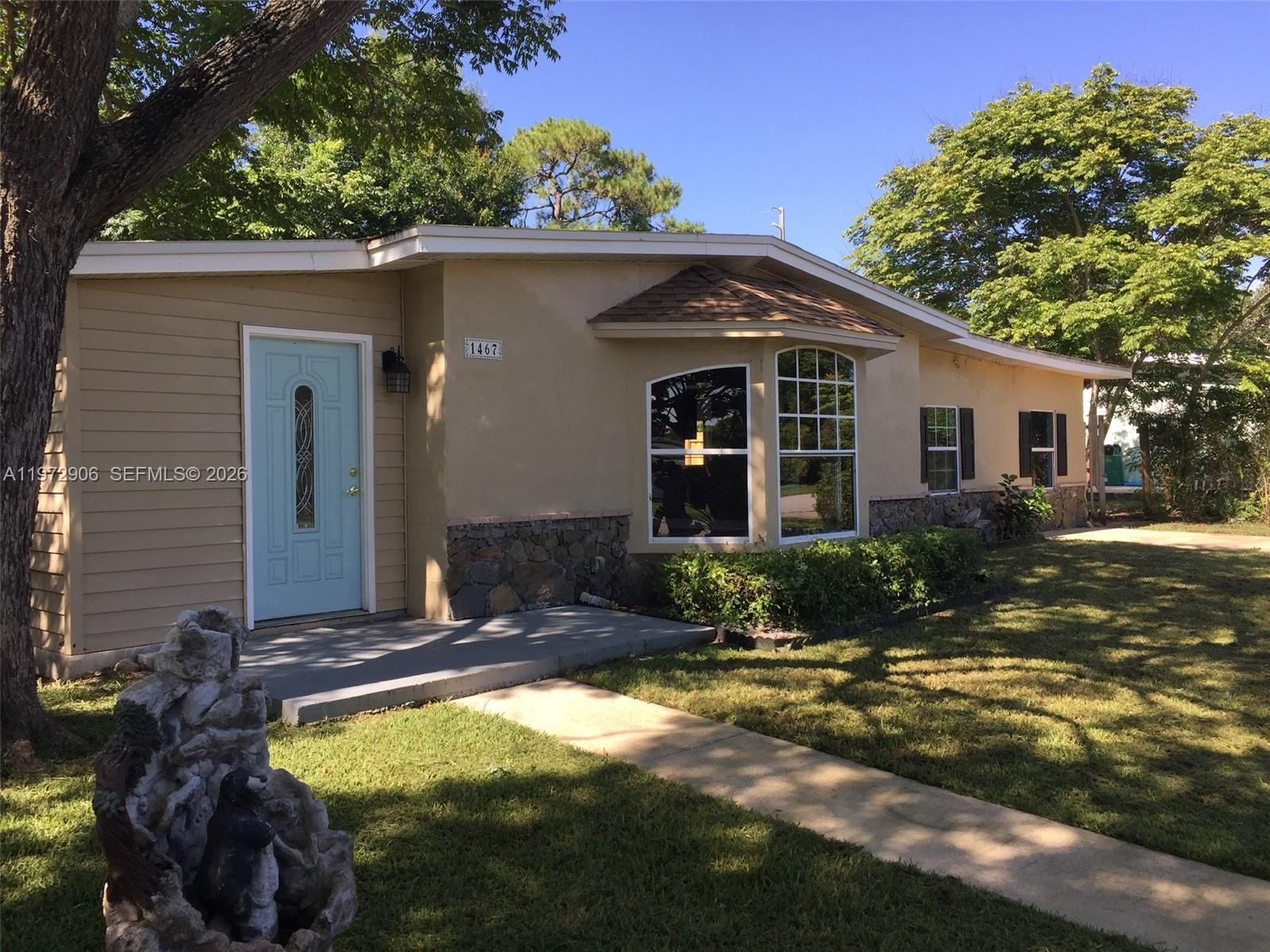 A single-story house with a light blue door, stone accents, and a bay window — 1467 Renton St., Deltona FL 32725, DELTONA, FL