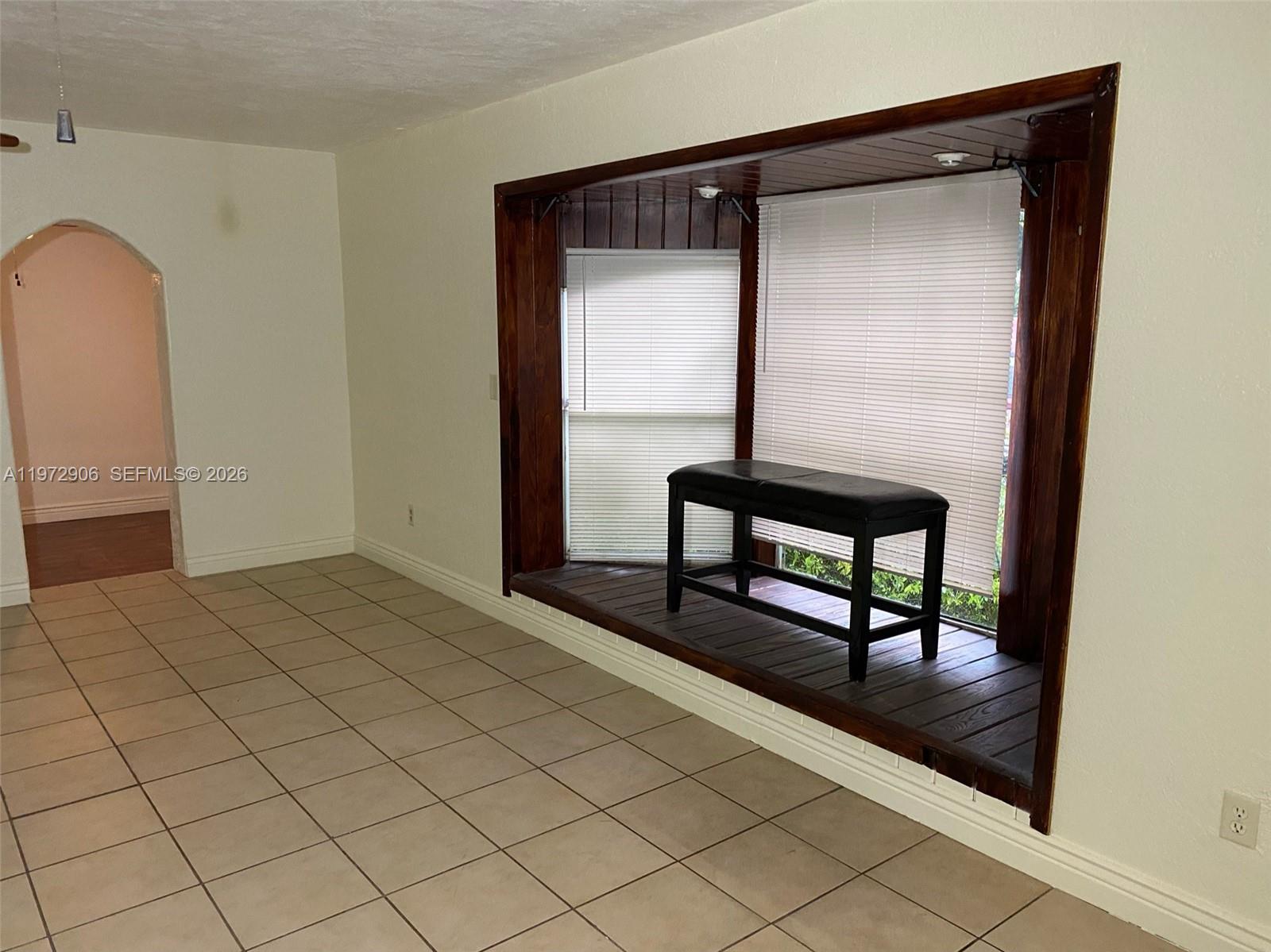 A room with tiled floors features a large wooden bay window area with a bench — 1467 Renton St., Deltona FL 32725, DELTONA, FL