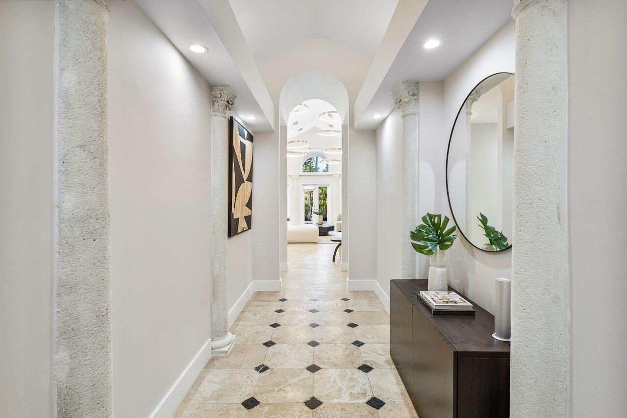 A hallway features stone columns, a tiled floor with black accents, and a round mirror — 200 NE 2nd Street, Boca Raton FL 33432, BOCA RATON, FL