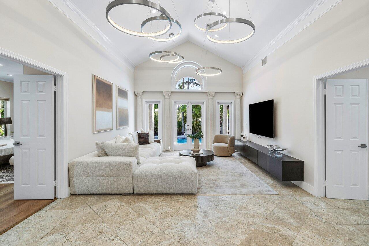 A bright living room features a vaulted ceiling, modern ring chandeliers, and a large sectional — 200 NE 2nd Street, Boca Raton FL 33432, BOCA RATON, FL
