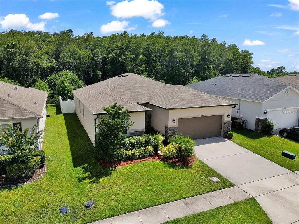 An aerial view of a single-story house with a tan stucco exterior and stone accents — 4548 ORCHARD GROVE ROAD, ST CLOUD, FL