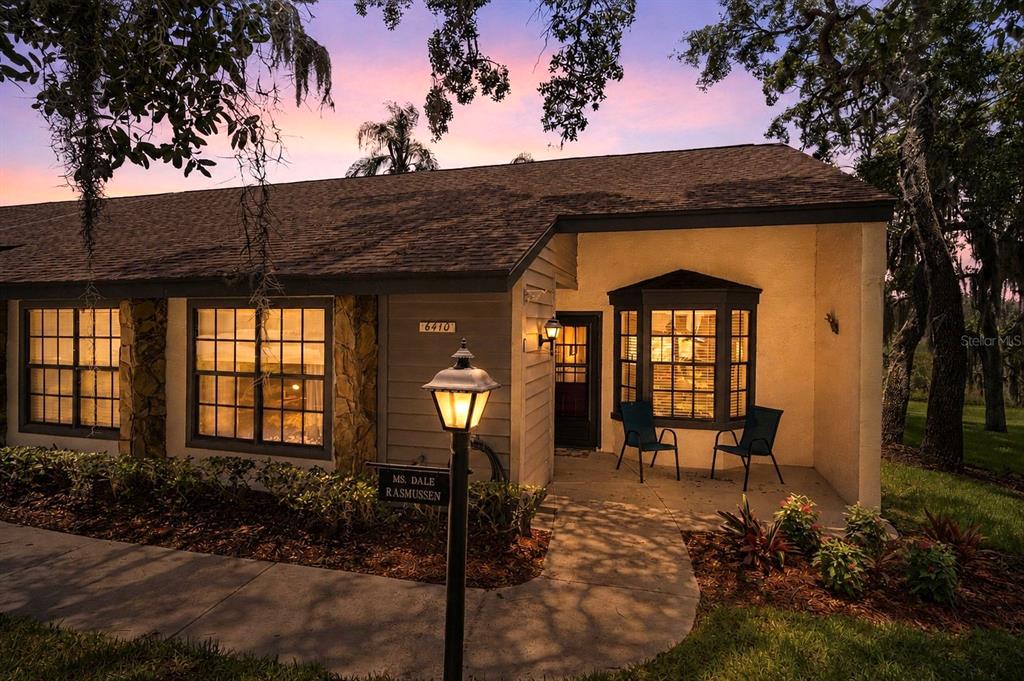 A single-story house exterior features a stone-accented facade, a bay window, and a front walkway — 6410 NATURE PRESERVE LANE, SPRING HILL, FL