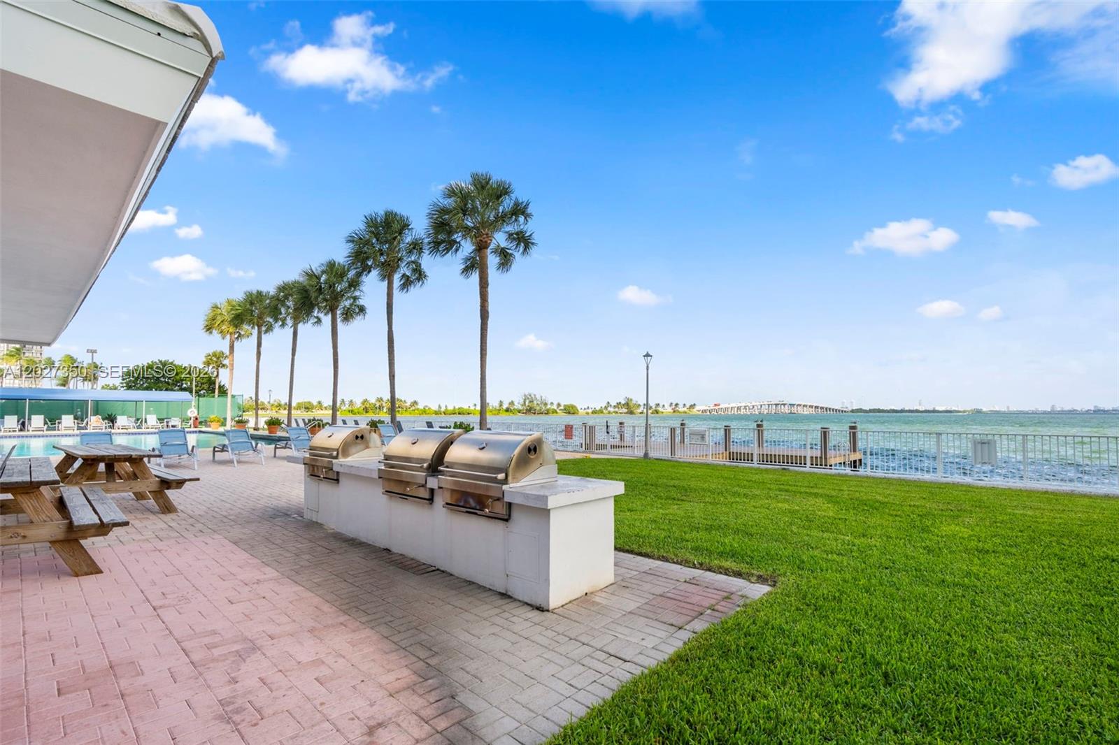 An outdoor patio features a built-in grill station, picnic tables, and views of the water — 3301 NE 5th Ave # 608, Miami FL 33137, MIAMI, FL