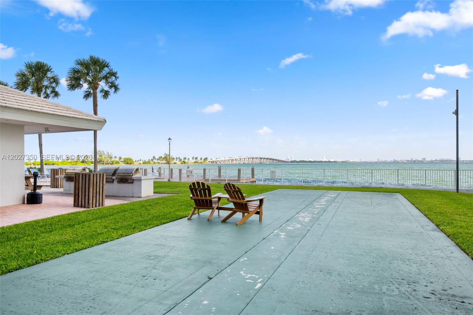 A patio area features two wooden chairs, a grill station, and a view of water — 3301 NE 5th Ave # 608, Miami FL 33137, MIAMI, FL